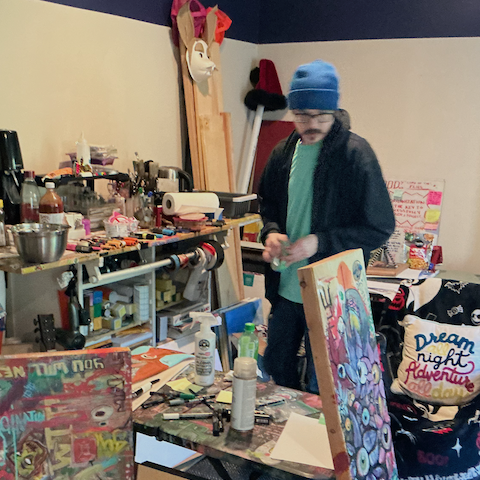 Jason Breish in his studio surrounded by colorful artworks